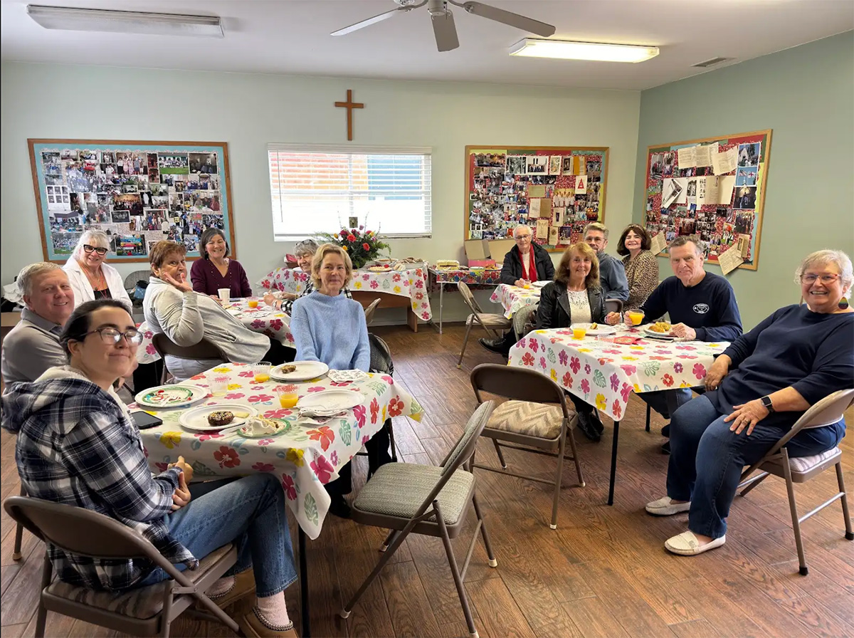 Parishioners pose at various tables after sharing coffee hour refreshments.