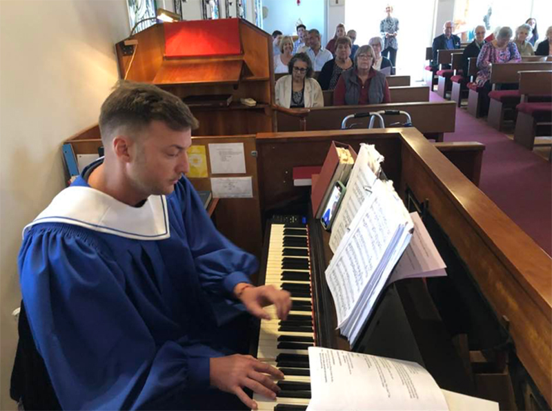 Organist Adam Behlen plays the organ in a full sanctuary.