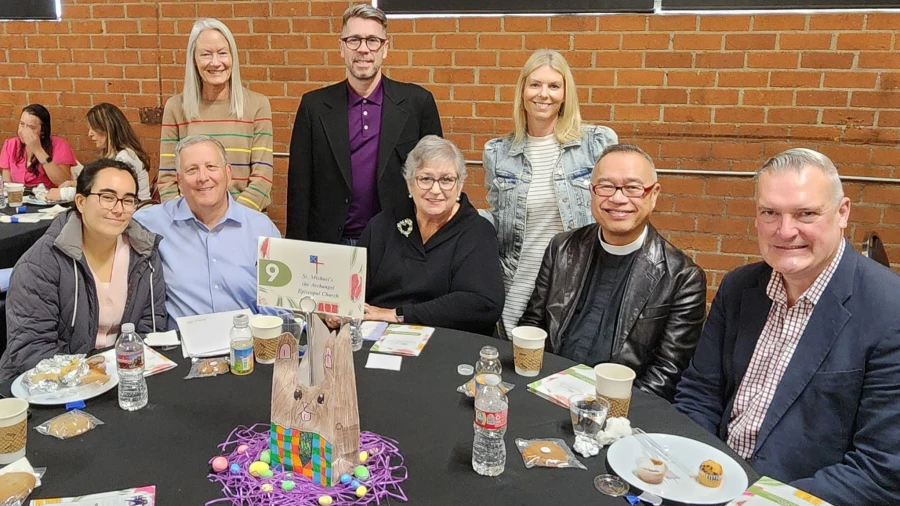 A group of church-goers pose at a table after sharing coffee hour refreshments.