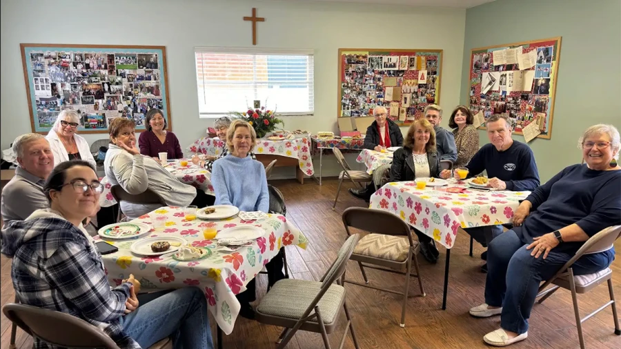 Parishioners pose at various tables after sharing coffee hour refreshments.