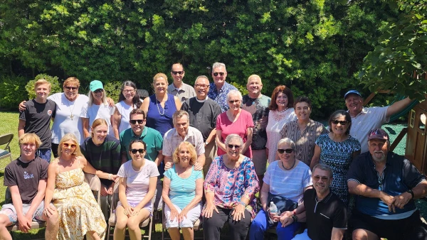 Parishioners and their families pose outside at a large picnic gathering.
