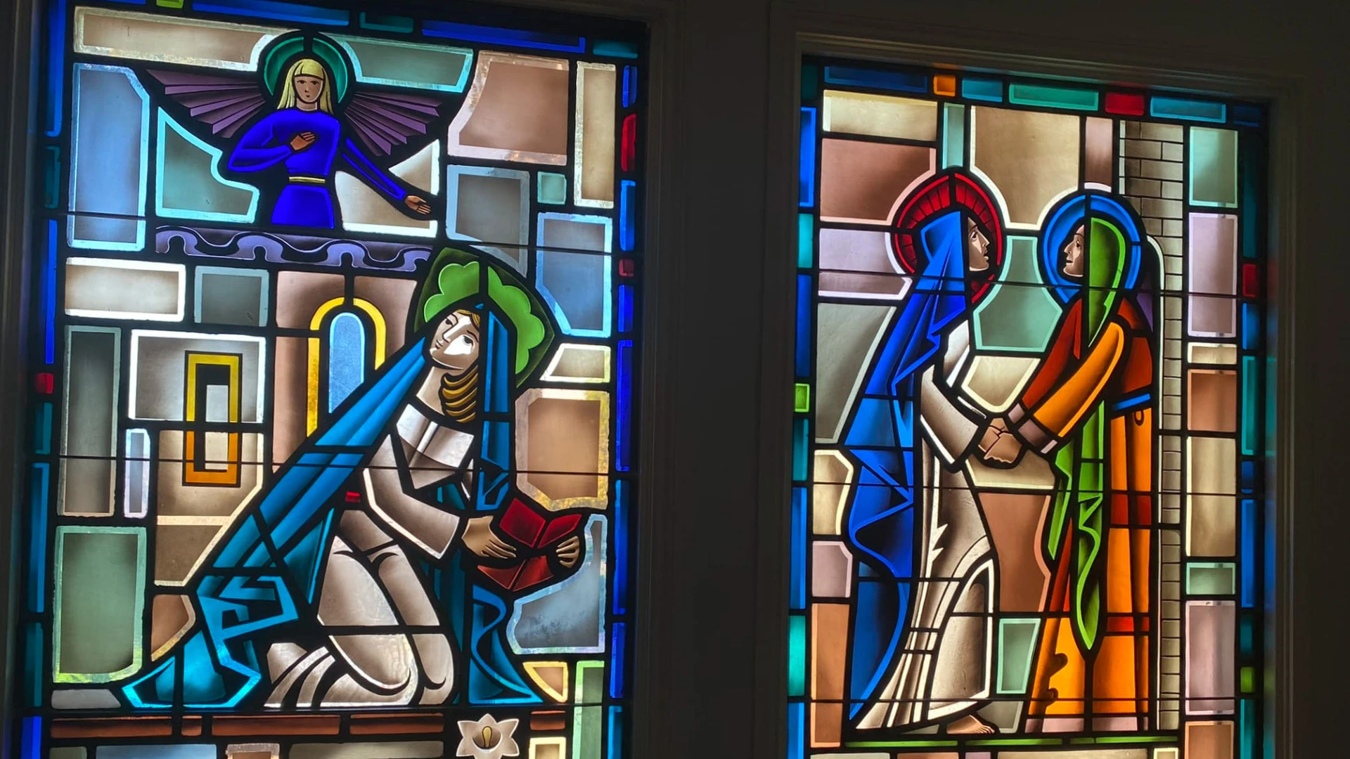 Two vibrant stained glass windows. On the left, titled