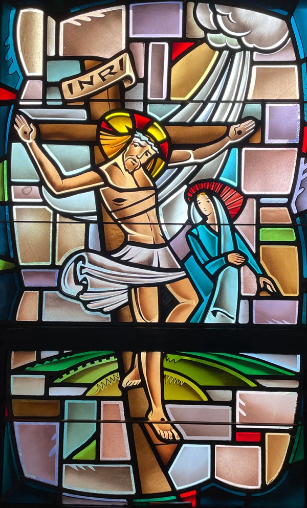 Stained glass window: Jesus is crucified on the cross and his mother looks on.