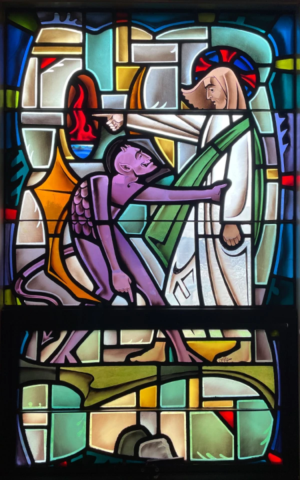 Stained glass window: A purple devil holds onto Jesus, who points away.