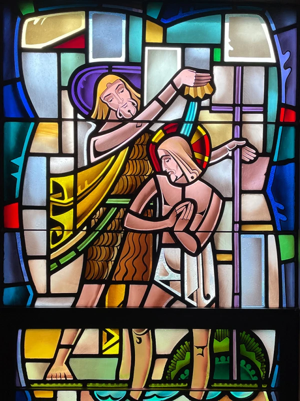 Stained glass window: John the Baptists baptizes Jesus.